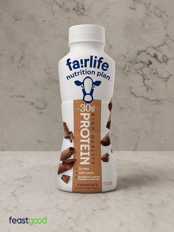 Bottle of fairlife nutrition plan protein shake with 30g protein, chocolate flavor, on a marble surface; FEASTGOOD watermark bottom left